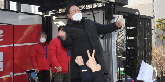 윤석열 국민의힘 대선 후보가 17일 오후 서울 송파구 석촌호수 서호 인근 사거리에서 열린 유세에서 환호하는 지지자들을 향해 '어퍼컷 세리머니'를 하고 있다. <연합뉴스>